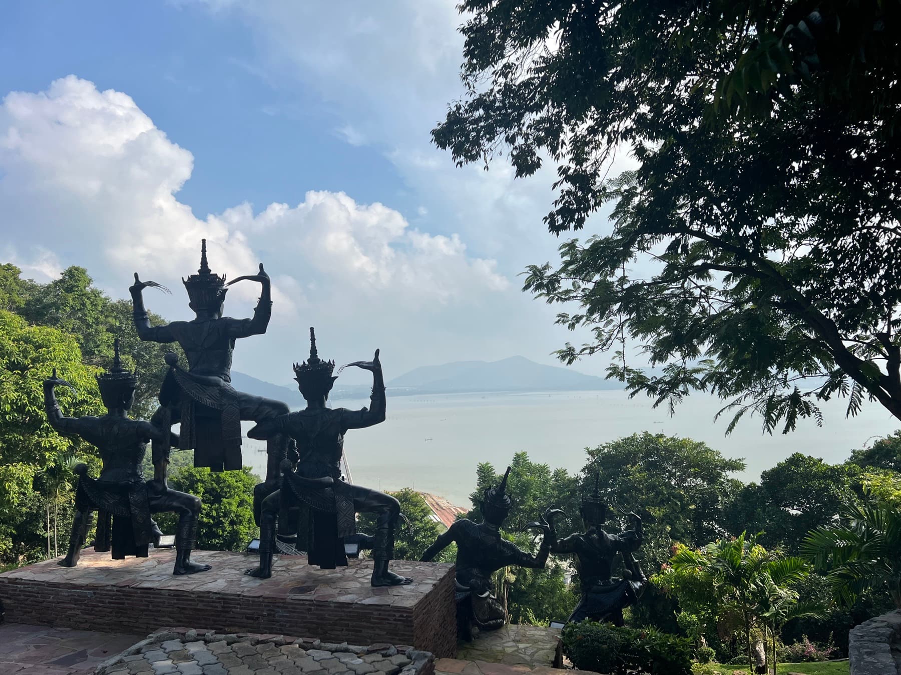 Bronze statues of Nora dancers on a hill overlooking the Songkhla Lagoon, mountains in the distance