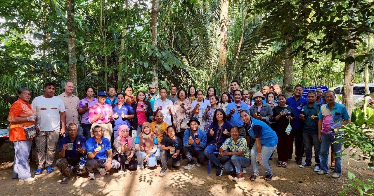Leaders of the Wanakaset Symbiosis Network gathered in their agroforest in the Songkhla Lagoon Watershed, holding regenerative products from the network